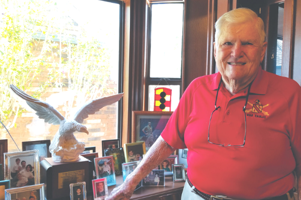 Jerry Orr stands near a window in his home office that is filled with photos and memorabilia. The Eagle statue is the Major General Douglas O. Dollar Distinguished Service Award for distinguished community service and citizenship that Jerry received in 2013.
