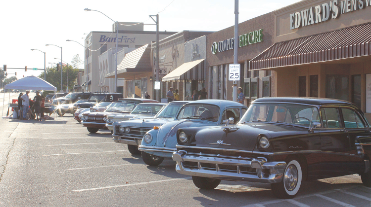 Several vintage cars from Stan Oldham’s collection were showcased along C Avenue in Lawton during the Sept. 5 Ware on C Block Party. Oldham, standing left, admitted to taking three hours to get the cars ready for the event.