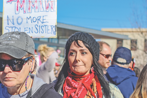 A woman marches with a “No More Stolen Sisters” sign at a Women’s March in Tulsa in 2018.