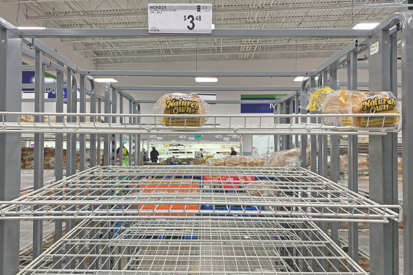 Shoppers are seen in the background behind a near-empty bread shelf at a Sam's in Lawton. Ledger photo by JJ Francais