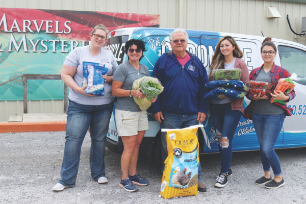From left, Medicine Park Aquarium & Natural Sciences Center staff members Nicole Rowe, Rainette Rowland, Doug Kemper, Nicole Hill and Jacey Smith scoop up armfuls of donated produce and feed, ready to deliver it to the variety of animal species housed at the aquarium on April 6. Hilliary Communications recently purchased fresh vegetables, berries, frozen raw shrimp, quail food and other needed items for the aquarium. Hilliary Communications donated an extra $2,000 to cover animal food costs for a month. . 