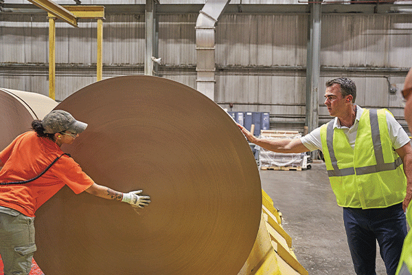 Gov. Kevin Stitt, right, examines a large roll of paper at Republic Paperboard Company in Lawton. Ledger photo by Chris Martin