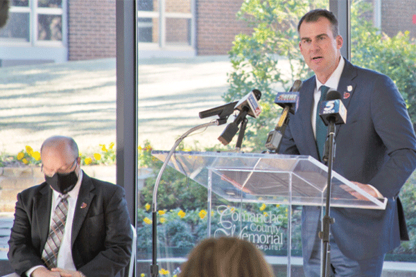 Oklahoma Gov. Kevin Stitt, right, addresses members of the press concerning the first shipment of COVID-19 vaccine sent to Comanche County Memorial Hospital in Lawton Wednesday The coronavirus is said to have been the cause of death for 306,000 people across the United States since March. Of those, 2,128 were Oklahomans, according to the Oklahoma State Department of Health’s most recent numbers.