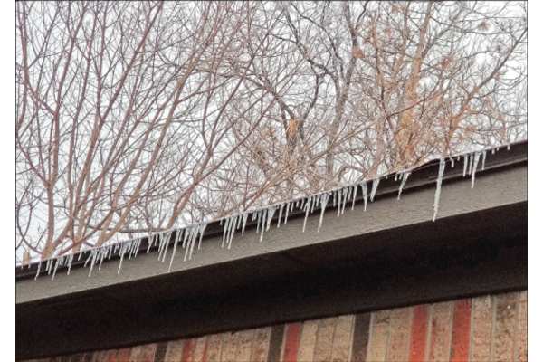FILE PHOTO BY DEBI DeSILVER - Icicles hang from a rooftop following February's winter storm in central Oklahoma