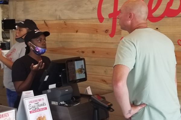 Employee Desare Easley takes an order from customer Josh West.