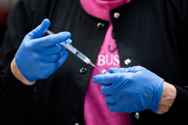 A healthcare worker fills a syringe with Pfizer’s COVID-19 vaccine. Whitney Bryen | Oklahoma Watch