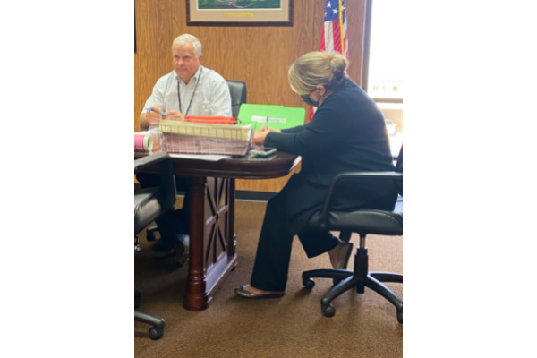Photo by Eric Swanson. From the left: Comanche County Commissioner Alvin Cargill and Comanche County Clerk Carrie Tubbs review paperwork during Monday's Board of Comanche County Commissioners meeting. The board tabled a request to organize the Pecan Valley Waterworks Association as a rural water district.