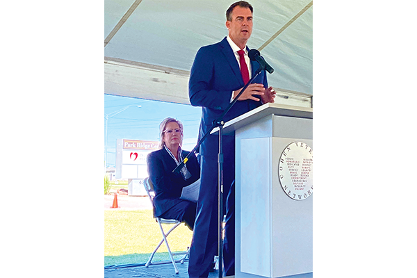 Red Rock Behavioral Health Services CEO Verna Foust (at back) listens as Gov. Kevin Stitt addresses the audience at the Oct. 21 grand opening for the Steven A. Cohen Military Family Clinic at Red Rock in Lawton. The clinic serves post-9/11 veterans, active-duty soldiers and their families. Eric Swanson/Ledger photo