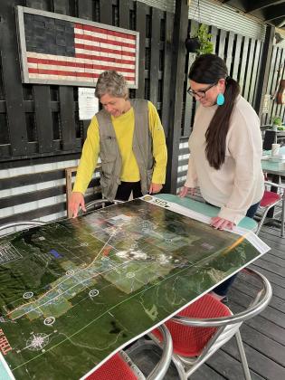 Dian Jordan, left, of Hochatown Historical Association and Shauna Williams, Choctaw Nation of Oklahoma, examine a map of Hochatown. Jordan and others have been working for years to incorporate the small town. (Photo courtesy of Shellye Copeland) 