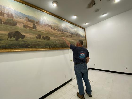 Paul Frable, board president for Holy City of the Wichitas, points out different structures on the recently restored mural. The mural was found in a damp museum storage room in 2017. Photo by Curtis Awbrey