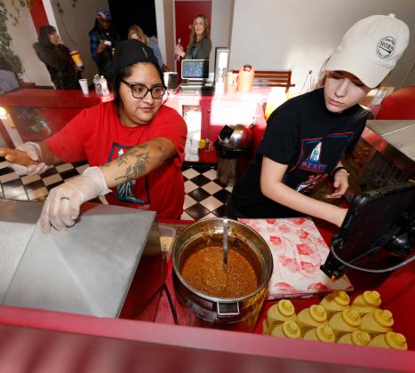 Gabby Nasel and jada Montgomery make chili dogs for patrons at Saturdays matinee screening of Avatar at the Liberty Movie Theatre in Carnegie. RIP STELL | SOUTHWEST LEDGER