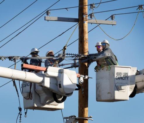 Public Service Co. of Oklahoma crewmen work on a power line in Tulsa earlier this year. PROVIDED