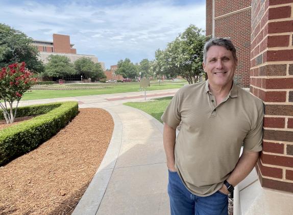 University of Oklahoma Prof. Keith Gaddie leans against the entrance to the Gaylord College of Mass Communication. Gaddie is retiring from OU and heading to Texas Christian University. M SCOTT CARTER | SOUTHWEST LEDGER