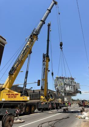 A pair of cranes from Allied Steel lift the damaged 63,000-pound industrial transformer off the street in preparation for loading it back onto a flatbed trailer. CURTIS W. AWBREY | SOUTHWEST LEDGER