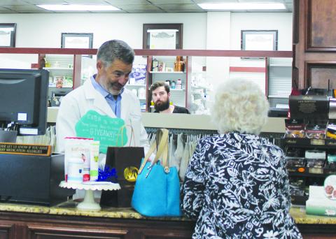 Southwest Ledger photo by Curtis Awbrey, Pharmacist and owner Shawn Anderson recently assists a customer.