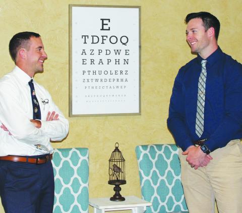 Southwest Ledger photo by Curtis Awbrey Optometrists Bryce Geiger and Michael Rice stand by the eye chart at Geiger Eye Care’s Elgin office. Both doctors are second-generation optometrists who attended Cameron University and Northeastern State University College of Optometry in Tahlequah.