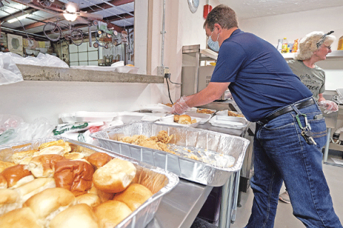 Volunteers at the Chickasha Soup Kitchen package hot meals that are handed out at the door to hungry recipients.
