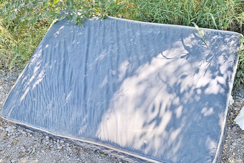 This mattress, trash bags, wooden box and broken shelves were laying in the bar ditches on either side of Railroad Street within a mile of Peacan Road on Monday.