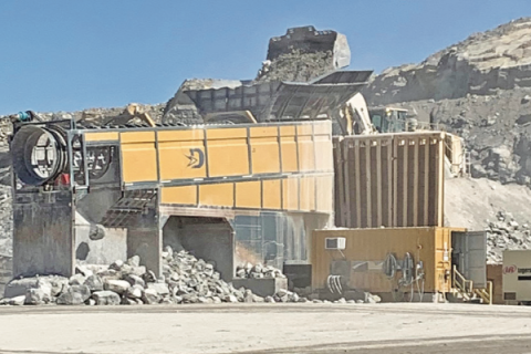 Ledger photo by Mike W. Ray         A front-end loader dumps raw material into a specialized machine that makes stone riprap – a pile of which is in the foreground – at Dolese’s Richards Spur quarry near Lawton.