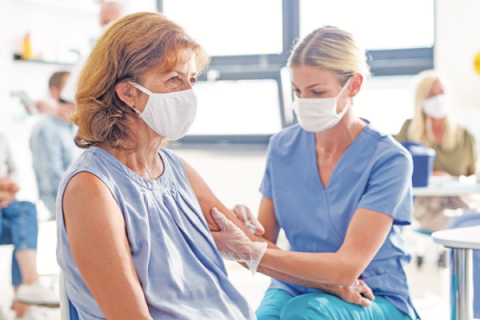 Nurse gives vaccine to patient.