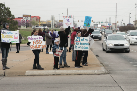 Motorists in Tulsa pass by demonstrators protesting cuts to state public education in 2018.