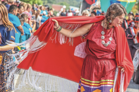 Photo provided         An Native American woman walks down a street during a Cherokee National Holiday parade in Tahlequah.