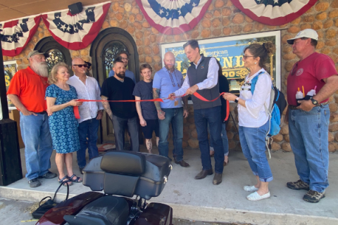 LEDGER PHOTO BY CURTIS AWBREY Oklahoma Lt. Gov. Matt Pinnell cuts the ribbon during a ceremony in front of American Legends Tattoo Shop in Medicine Park Sunday.