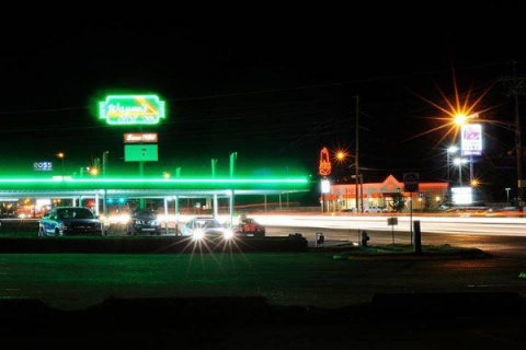 COURTESY JOE ABSHERE/WAYNE’S DRIVE INN - Vehicles are parked under neon-lit awnings at Wayne’s Drive Inn at 7 SW Sheridan Road.
