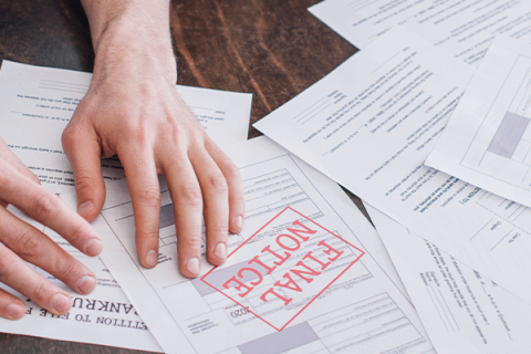 Hands on a pile of foreclosure nottices