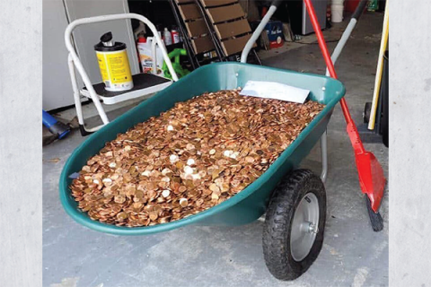 The weight of the pennies - approximately 500 pounds - cause the wheels of Andreas Flaten's weelbarrow to collapse. OLIVIA OXLEY/PHOTO PROVIDED