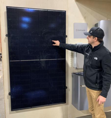 Sam Pearson, a solar consultant, explains the basics of a type of solar panel. Before joining EightTwenty, Pearson worked in the oil patch installing solar units to power oil/gas pumps.  MIKE W. RAY/LEDGER PHOTO