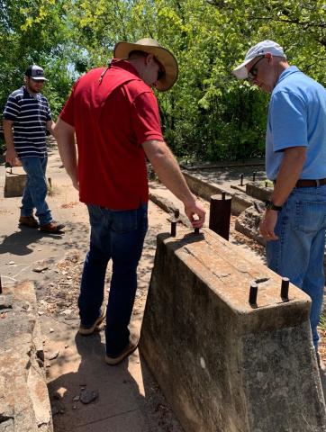 This abandoned well site northeast of Velma, off County Line Road, was once a pump station. Crude oil was pumped from here into a pipeline or a battery of tanks somewhere. Inspecting the site in July 2019, when it was approximately 90 years old, were Rodney Troglin and Roger Walkup, both with Beacon Environmental, and Steve Sowers, environmental director with the Oklahoma Energy Resources Board. The concrete was later broken up and buried and the site was revegetated.   Ledger Photo by Mike W. Ray