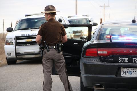 An Oklahoma Highway Patrol Trooper stands next to his vehicle JJ FRANCAIS/LEDGER FILE