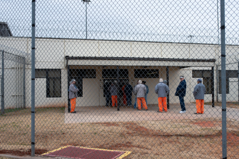 Inmates are seen lining up to receive their medication at Joseph Harp Correctional Center in Lexington. The Legislative Office of Fiscal Transparency identified the prison as having a strong jobs training program. (Whitney Bryen/Oklahoma Watch)