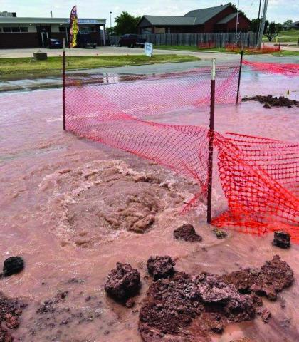 Water gushes from a broken water main in west Lawton in July.  Ledger photo by David B. Hale