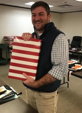 District Supervisor Jaremy Andrews for the Office of Juvenile Affairs displays a gift box he finished packing for one of more than 200 youths in OJA custody. The gifts were purchased with funds provided by the Santa Claus Commission. OFFICE OF JUVENILE AFFAIRS