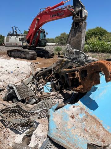 An excavator sits idle Aug. 6 near a pile of junk collected after a Union Pacific train derailed in Marlow two months ago, apparently when an axle on one of the cars came off. DAVID B. HALE | SOUTHWEST LEDGER