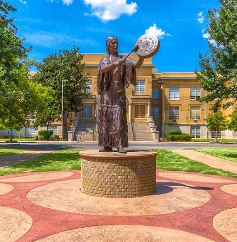 A statue of Te Ata, an actress and citizen of the Chickasaw Nation who was born in pre-statehood Indian Territory and became a celebrated First American performer, stands in the Oval at USAO. In the background is Troutt Hall, named for former USAO President Roy Troutt. PROVIDED