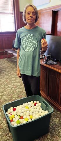 Liz Reed holds one of the 900 errant golf balls that have bombarded her property in the last four years. Mike W. Ray | Southwest Ledger