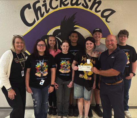 Stacy O’Neal and her robotics students at Chickasha High School receive a check for $1,700 from Mike Hixson