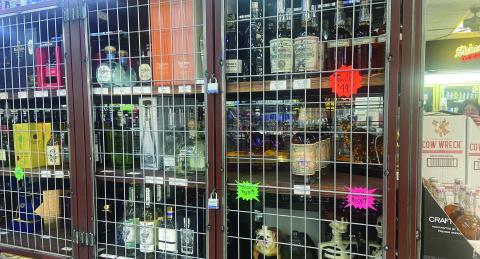 Eric Swanson | Southwest Ledger Liquor bottles are arrayed in locked metal cages in this photo taken Oct. 24 at Bootlegger’s Liquor in Lawton. On Nov. 5, Comanche County voters will decide whether retail liquor stores can open for business on Sundays.