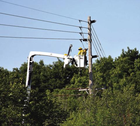 A pair of PSO linemen carefully maneuver their bucket under power lines and above the tree line to make repairs behind the Cameron University plant sciences complex on the west side of Southwest 38th Street. A high-voltage electricity transmission line that traverses Comanche, Stephens and Carter counties will be replaced in a multiyear project that will cost an estimated $260 million. Scott Rains | Southwest Ledger