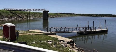 A dock and the earthen dam at Lake Chickasha on June 5, 2024. Later this year the City of Chickasha is expected to solicit bids on repairs to the dam in preparation for raising the height of the lake by 10 feet. Mike W. Ray | Southwest Ledger
