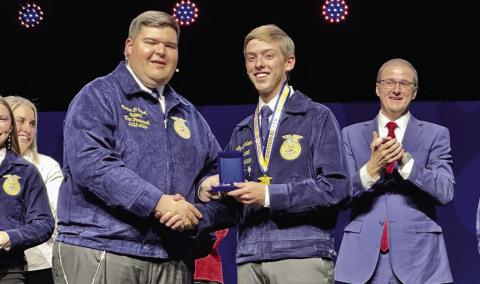 Elgin FFA’s Coy Davidson (center) receives the National Championship Medal for Prepared Public Speaking at the 97th National FFA Convention and Expo in Indianapolis Thursday. It was reported that more than 70,000 students and guests attended the event. Approximately 2,000 attendees came from Oklahoma. Ron Hayes| Oklahoma Farm Report