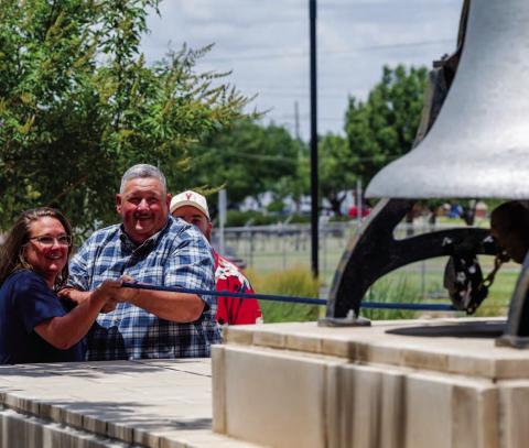 Greg Ellis and his wife Dawn Ellis ring the bell Thursday at the Lawton Public Safety Facility to mark his retirement after 29 years of service with the Lawton Police Department. Stephen Miller | Southwest Ledger